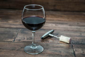 glass of wine with a corkscrew