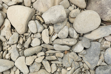 Background and texture of small stones next to a river.