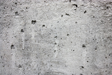 Texture of gray concrete with cracks and pores.