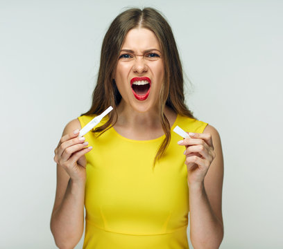 Frustrated emotional woman holding pregnant test pack.