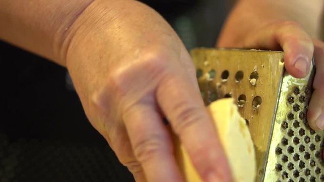 hard cheese rubbed on a metal grater. Slow motion. close-up