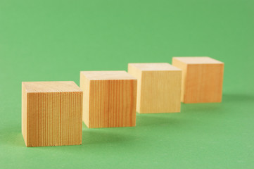 wooden geometric cube on a green background