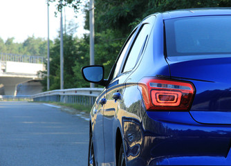 Rear lights of blue car is ready for driving on the highway