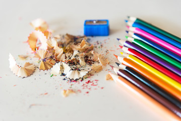 A lot of colored pencil shavings on a white background on the table