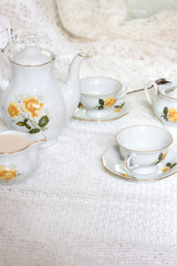 Antique tea-set with sugar and milk on white table close-up