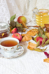 Vintage tea party - tea cups, apples and honey on white wooden table