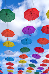 Obraz premium Multicolored umbrellas hanging high above the ground