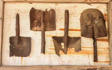 rusted shovels on wood frame
