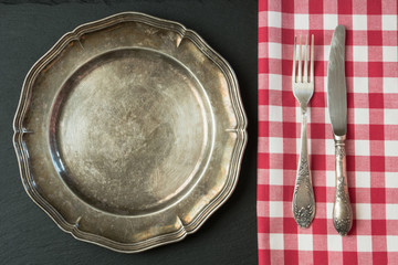 Empty metal plate with silverware on black, with copy space for your menu or recipe. Menu card for restaurants. © svetlana_cherruty