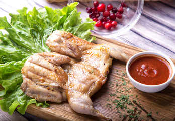 Roasted Quail with  cowberry sauce on the wood background