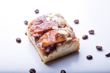 Piece of apple pie isolated on white background with almond flakes and coffee grains