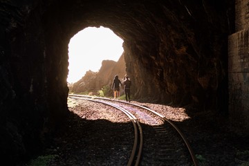 Friends & Dogs walking on a path & railroad close to the beach sunset