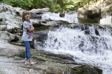 Girl next to the Waterfall of the bucket in the Selva de Irati in Navarra, Spain.