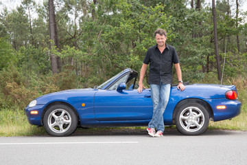 View of a young male next to his convertible car