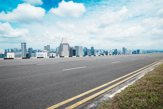 empty asphalt road with modern buildings in blue sky