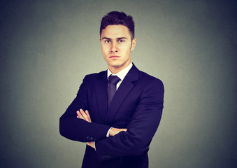 Portrait of confident young businessman isolated on gray background