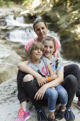 Family sitting on some rocks next to a river in the Irati Seva of Navarra, Spain.