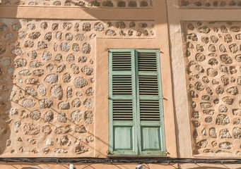 Fensterladen vor einem Fenster eines mediterranen Hauses