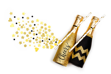Card with word Cheers with black and gold champagne bottles. Flat lay, top view.