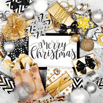 Merry Christmas Card with black and gold Christmas gifts, bows and decorations. Flat lay, top view.