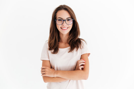 Smiling brunette woman in eyeglasses posing with crossed arms