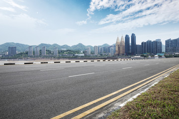 empty asphalt road with modern buildings in blue sky