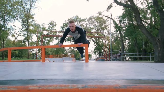 Young man doing parkour tricks in extreme sports park