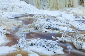Winter creek covered by ice and snow. Typical northern swamp water color.