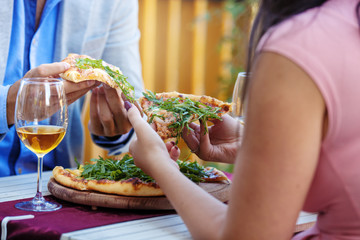 Close up. Couple's Hands Taking Pizza Slice.