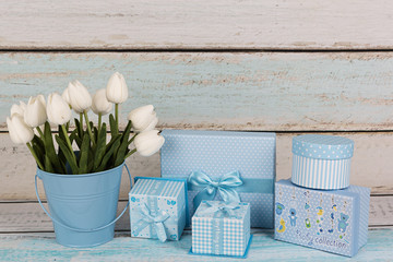 Cajas para bebés y tulipanes blancos.