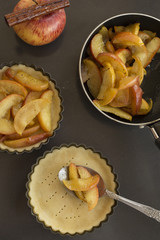 Work with the dough. Form for baking and ingredients for apple pie. The process of preparation of apple tart. View from above. Flat lay.