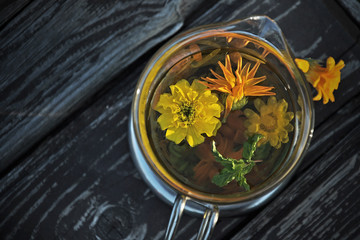 Cup of infusion of marigold with Calendula flowers and mint 