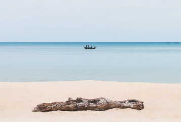 Fototapeta na wymiar Timber on the beach and fisherman fishing on boat background