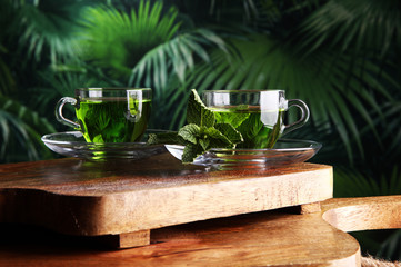 cups of tea with mint on wooden table