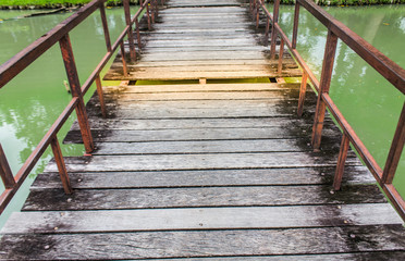 Fototapeta premium The wooden bridge in the damaged park at the time of walking is dangerous. Need maintenance