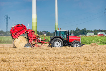 Traktor mit Rundballenpresse auf dem Feld - 0261