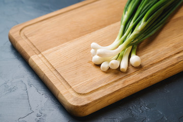 Green onion on the wooden board.