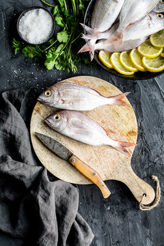 Sea bream on a cutboard with some ingredients