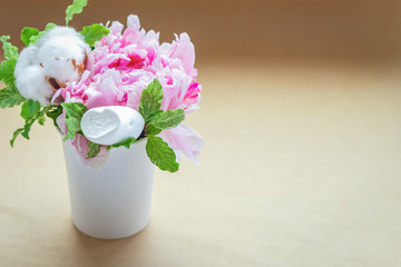 bouquets of peonies in a small craft cup