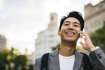 Happy businessman talking on smart phone in city
