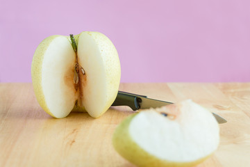 Peeling chinese pear by knife on the wooden board