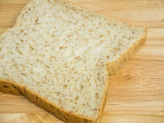 Slice whole wheat bread on wooden table