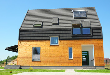 Modern house with energy saving and energy efficiency. Eco-house or  wooden eco-home with attic skylights, insulation, solar panels and solar water heater (SWH) system. Passive House Concept. - obrazy, fototapety, plakaty