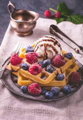 Belgian waffles with ice cream, chocolate sauce and fresh berries
