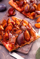 Slicesd german plum cake on wooden table