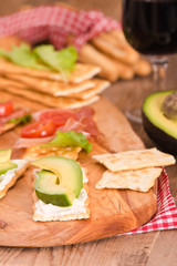 Crackers with ham and avocado. 