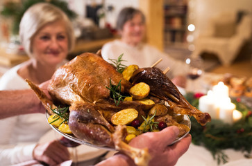 Family celebrating Christmas. Roasted turkey on tray.
