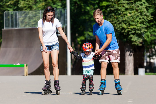 Cute Baby Boy And His Mom Learning Inline Skating With Skating Instructor.