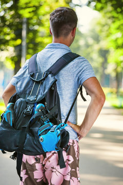 Young male roller skater with roller backpack - shoot from behind.