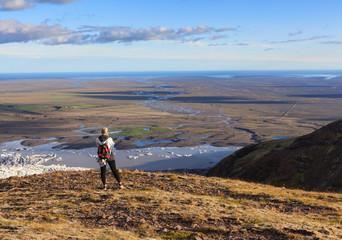 Obraz premium Icelandic adventure. Travel in Iceland. Girl with backpack hiking on mountains 